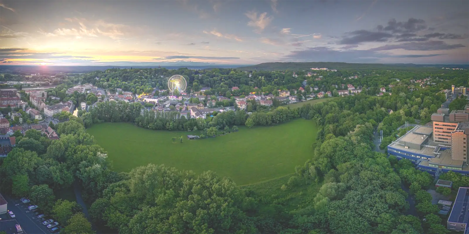 Erlangen aus der Luft am Abend, mit dem beleuchteten Riesenrad der Bergkirchweih